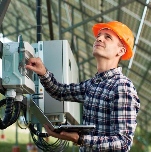 usinas solares fotovoltaicas - homem inspecionando o quadro distribuidor